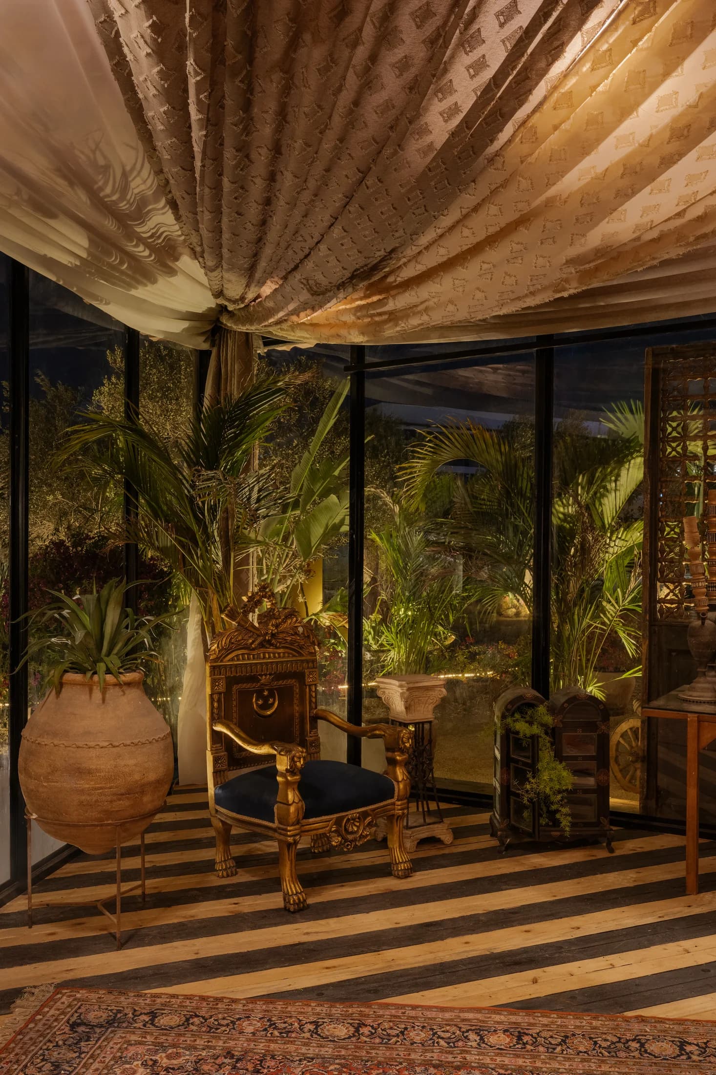 Draped ceiling, indoor planting and striped flooring beside Babbo's garden-facing windows