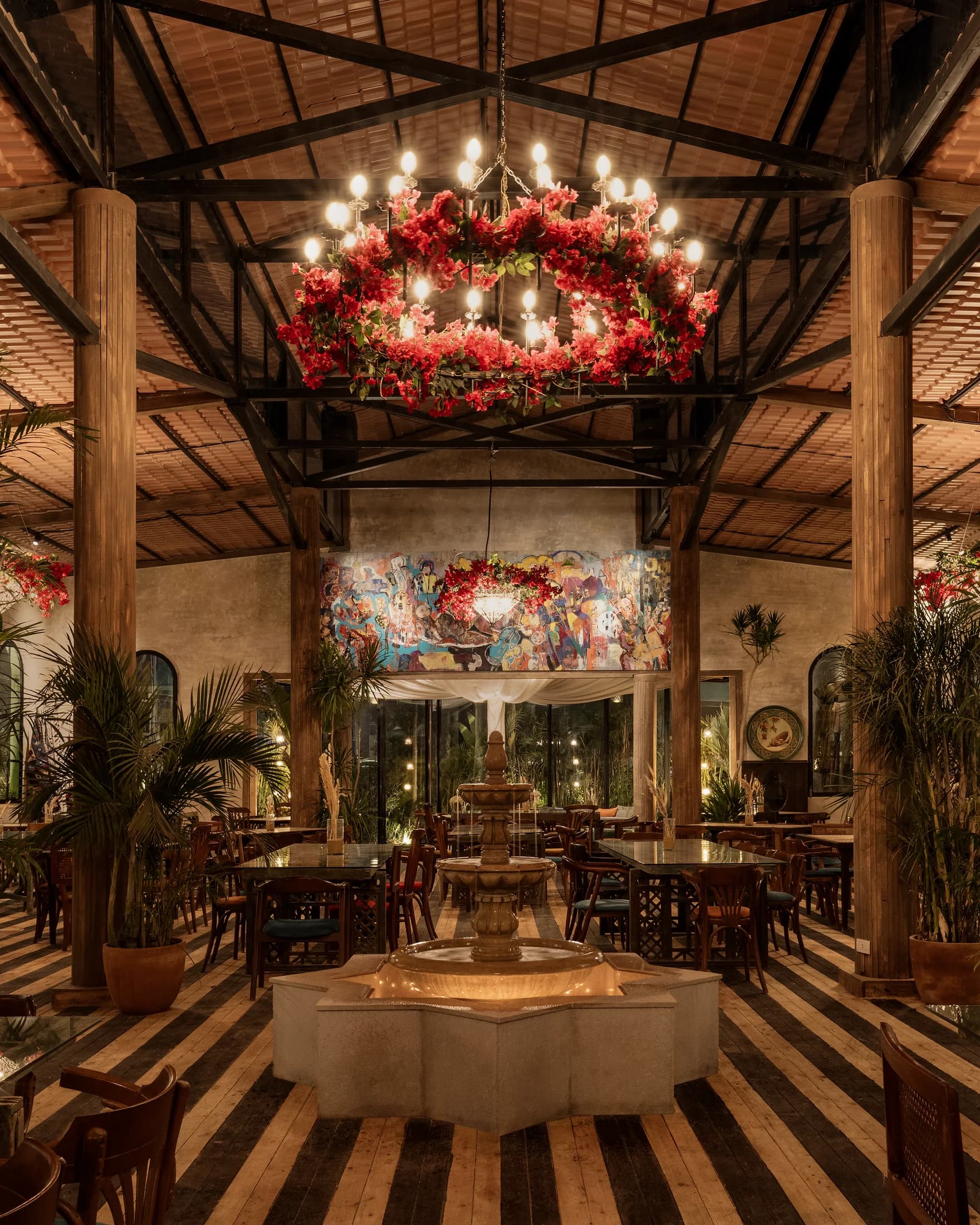 Babbo's dining room beneath a red floral chandelier and timber roof