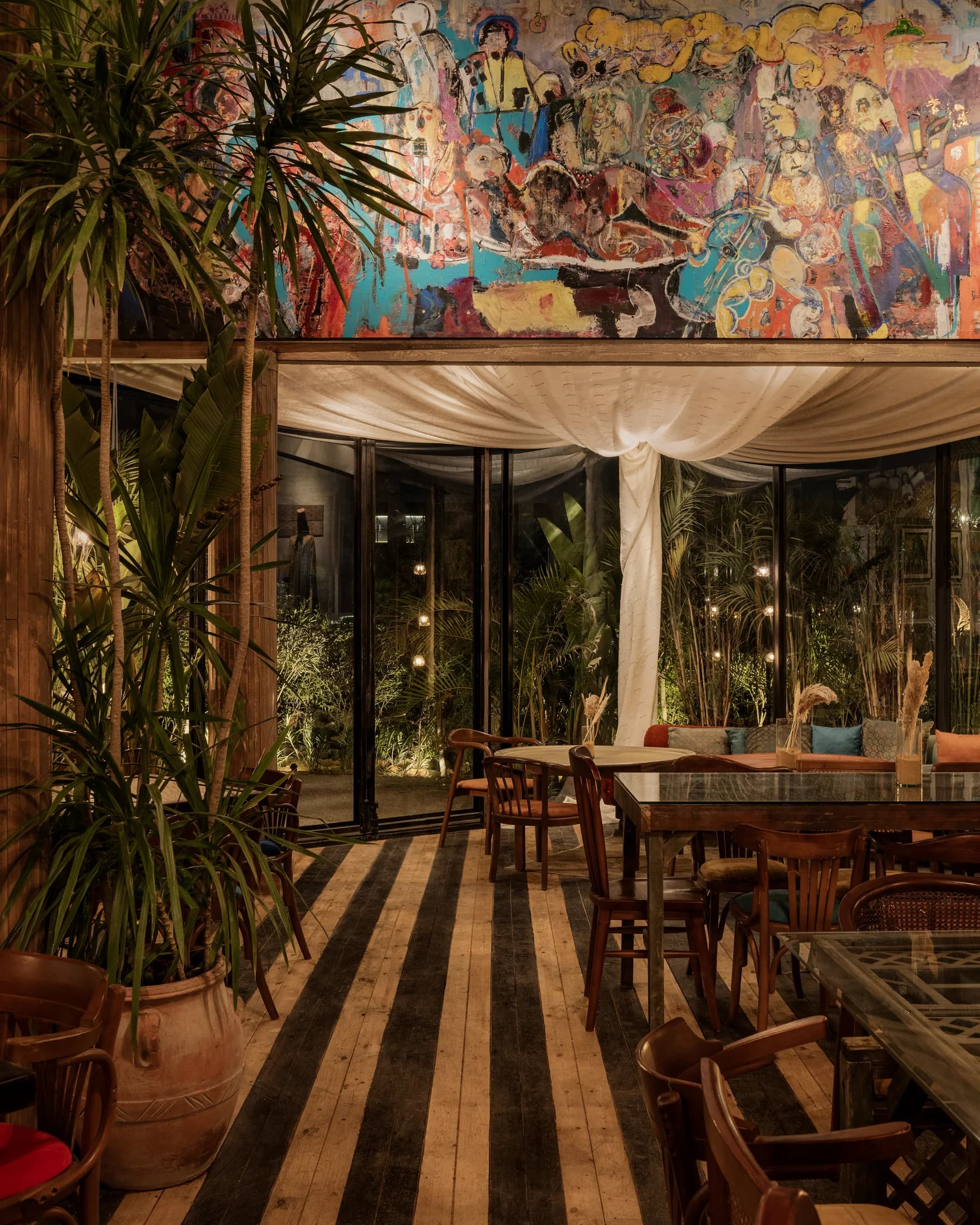 Colourful wall art above a draped opening into Babbo's dining area