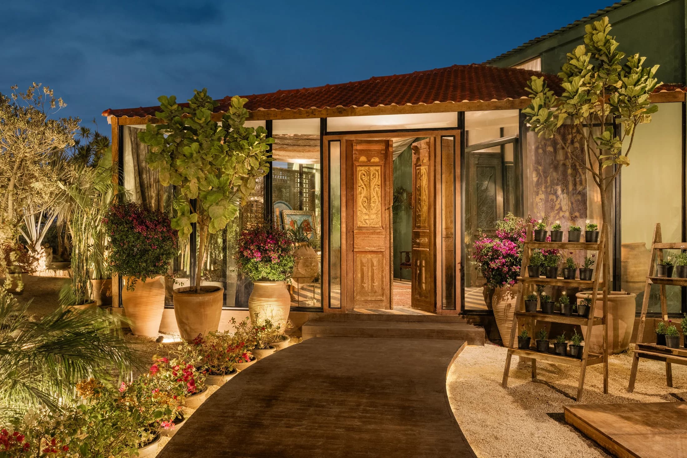 Babbo's illuminated entrance at dusk, framed by planting and a garden path