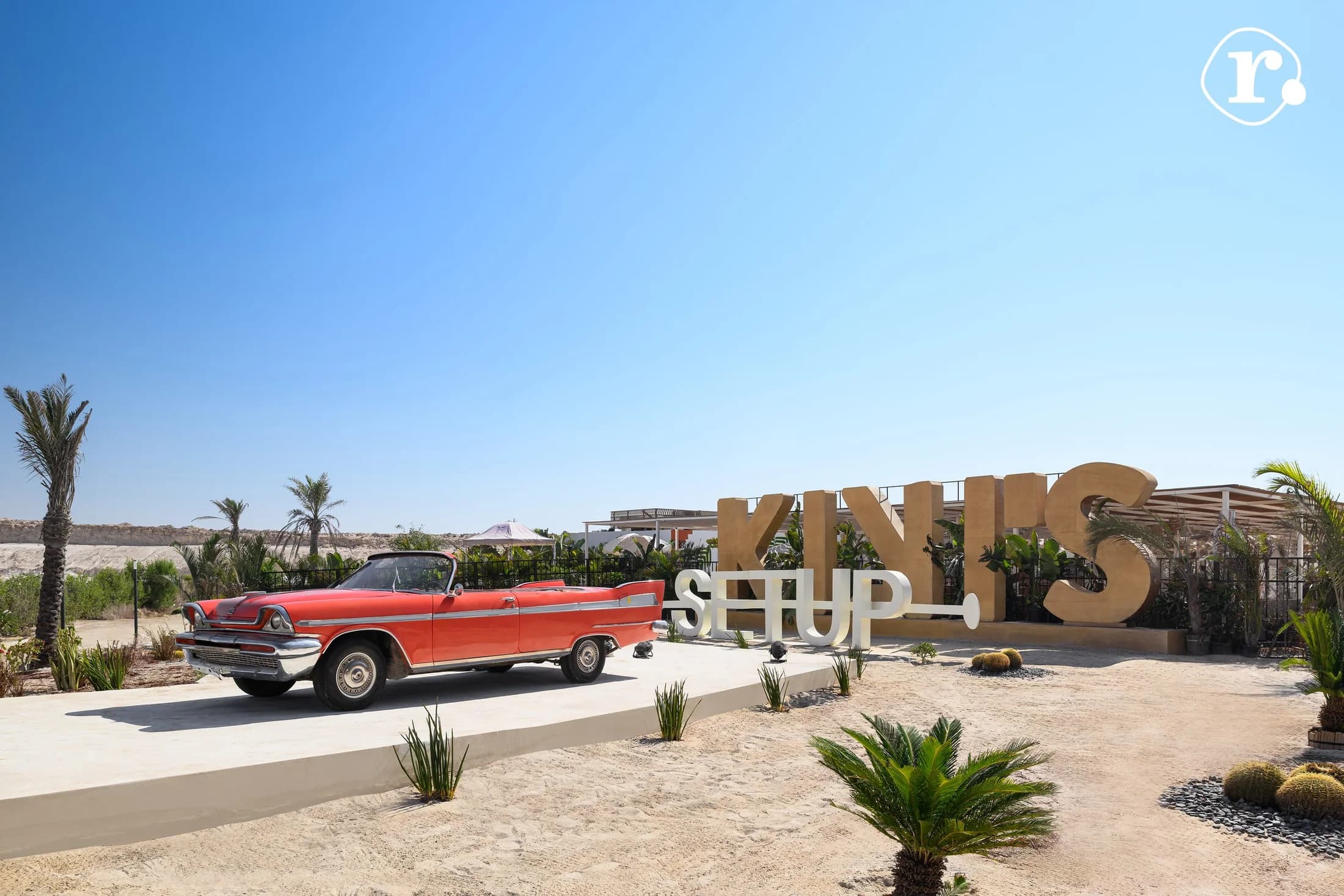 Kiki's arrival area with branded signage and a red classic car