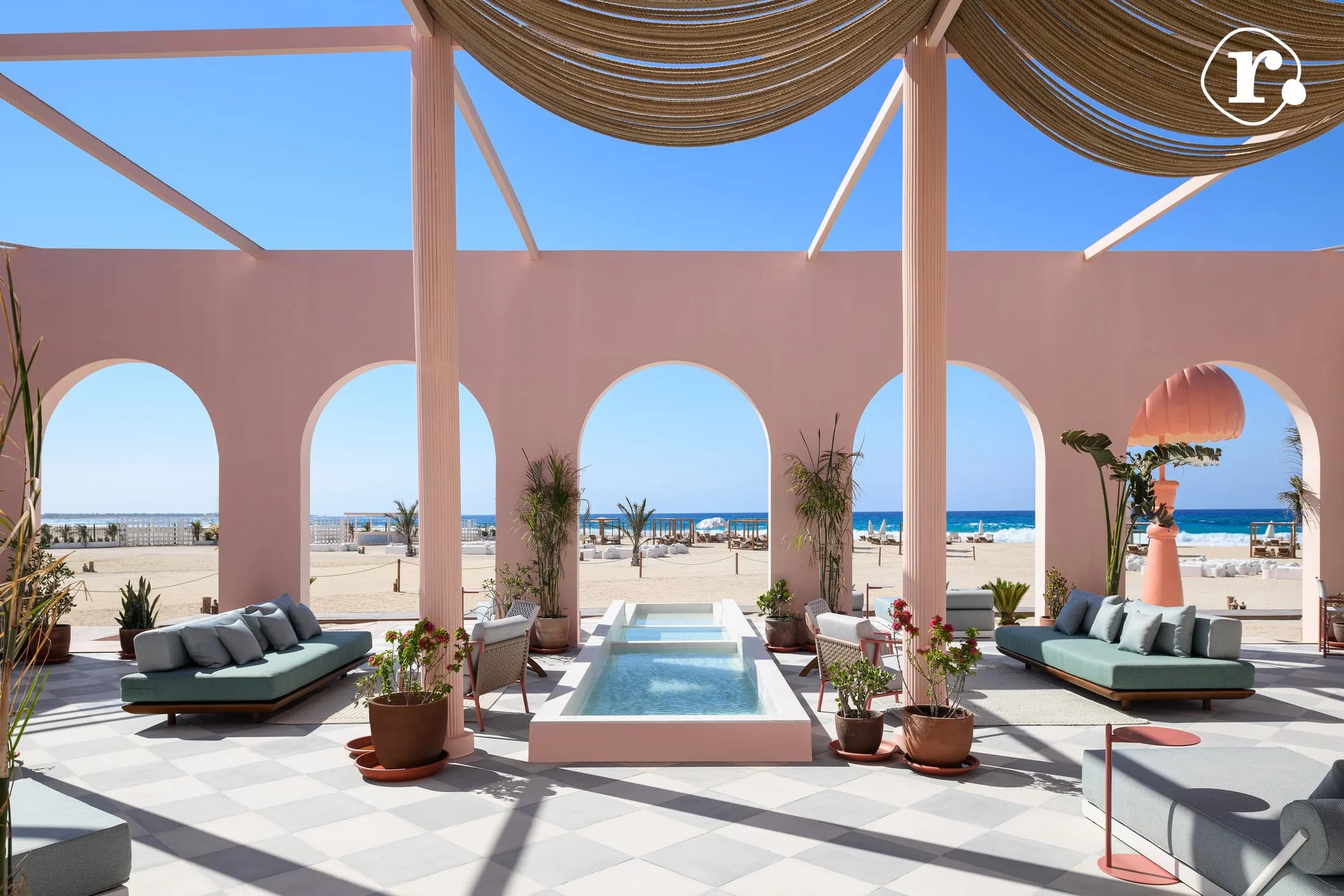 Sea-facing pool and gathering spaces framed by arches at Hacienda Heneish